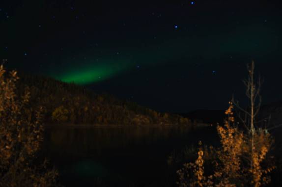 As cores da Aurora reflerem no Yukon River, em Dawson City, no noroeste do Canadá